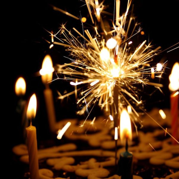 a birthday cake with sparkler and standard candles