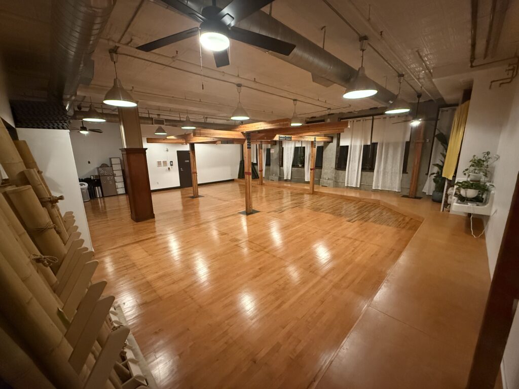 Our spacious Downtown Los Angeles (DTLA) studio features gleaming hardwood floors and a large wooden suspension frame in the center.