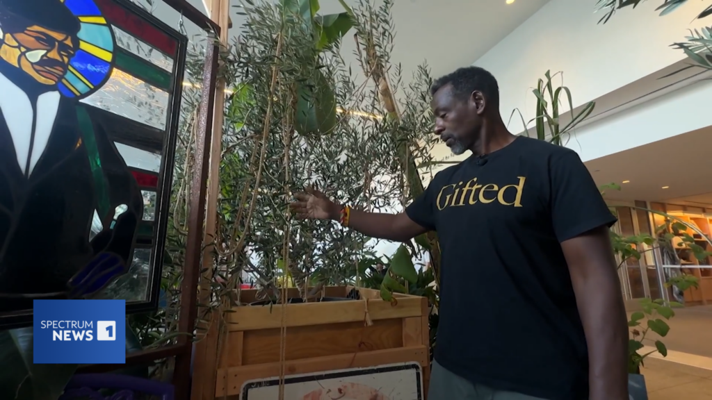 Ron Finley interacts with Andrew's rope on his plants as part of the BREATH(E) exhibit at the Hammer Museum, Los Angeles, September 2024.